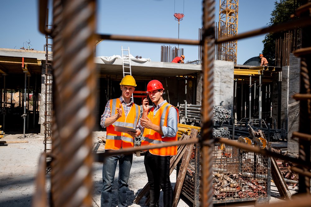 Two workers show approval at a job site as Ozark Grease Pros provides grease trap pumping in Northwest Arkansas.